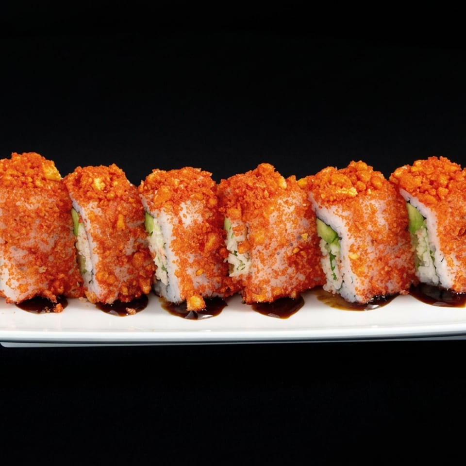 Sushi roll pieces coated in orange crunchy topping, filled with avocado, and drizzled with dark sauce on a white rectangular plate.